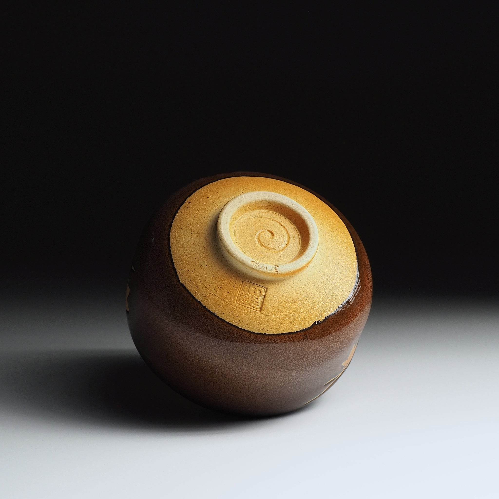 Yūkaede matcha bowl inverted, showing unglazed Shigaraki clay base, hand-finished foot ring and Taro Kojima seal