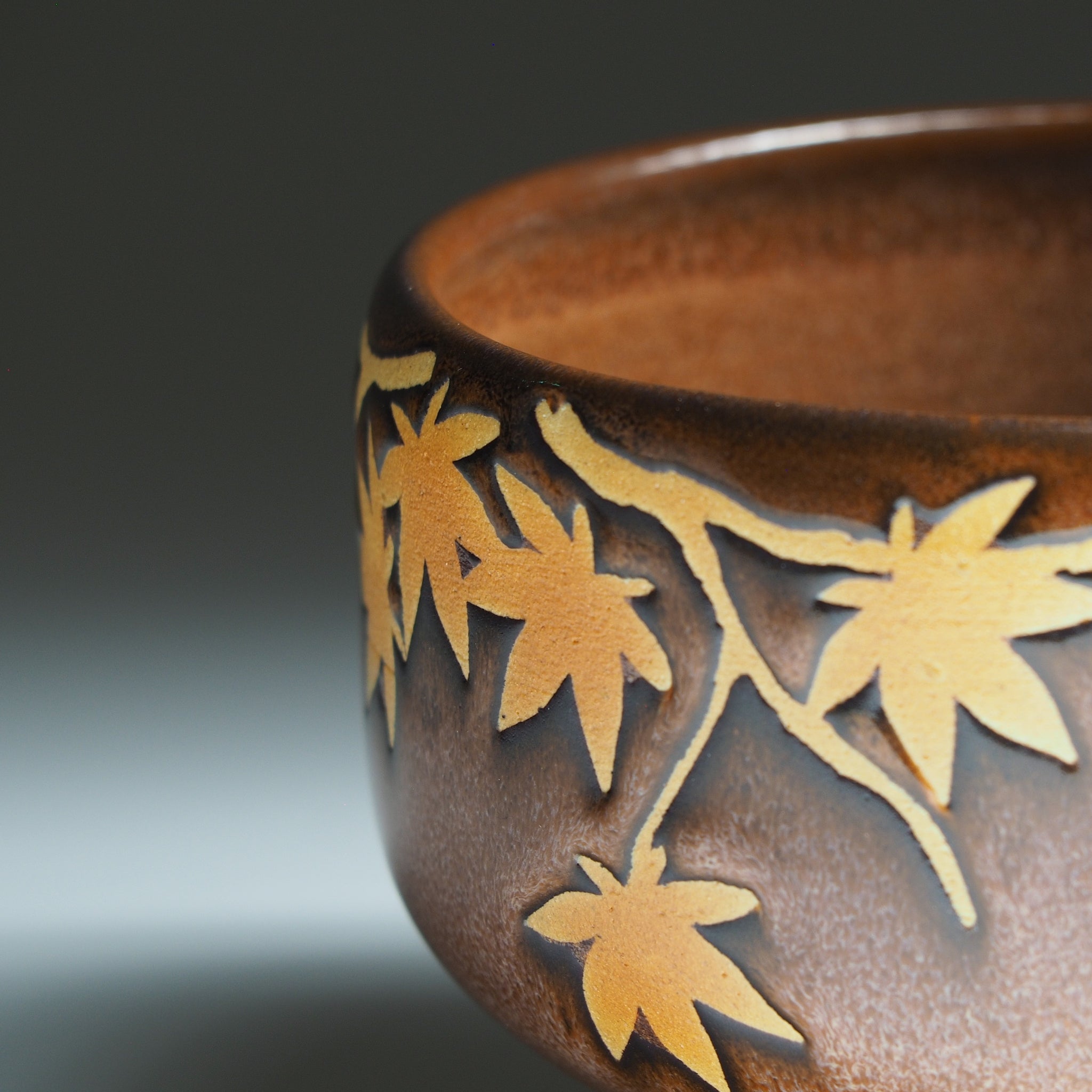 Yūkaede matcha bowl, momiji leaves in unglazed natural clay relief against Autumn Sienna Nanasai Tenmoku glaze, Japan