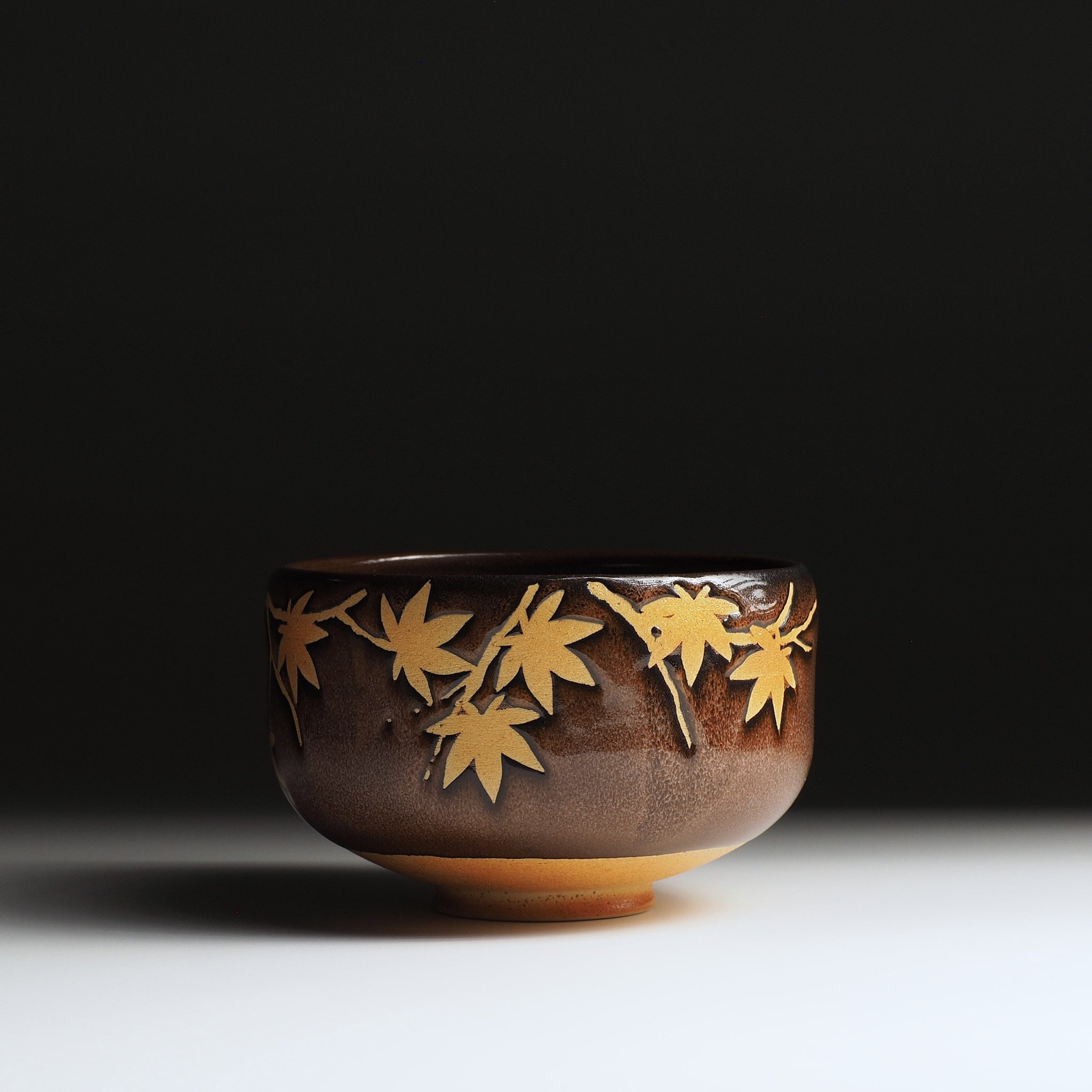 Yūkaede matcha bowl, front view, momiji negative-space decoration on Nanasai Tenmoku glaze, Taro Kojima, Nunobiki Kiln